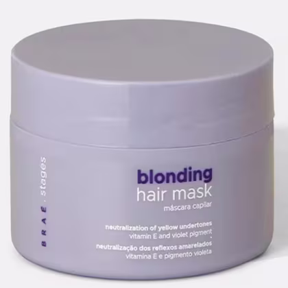 Embalagem circular cinza contendo máscara capilar para loiros, com rótulo indicando "blonding hair mask" e informações sobre neutralização de tons amarelados e pigmentação violeta.