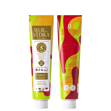 Creme dental Ayurvédico da marca Ayur Vedika. A embalagem é um tubo de cor amarela e laranja, com rótulos que destacam os ingredientes naturais utilizados, como romã, aloe vera, cúrcuma e 23 ervas ayurvédicas.