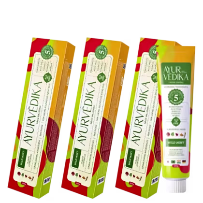 Três caixas de pasta de dentes da marca Ayurvedika, em cores vermelho, amarelo e verde. Cada caixa contém uma pasta de dentes com o nome "Ayurvedika" impresso em letras brancas.