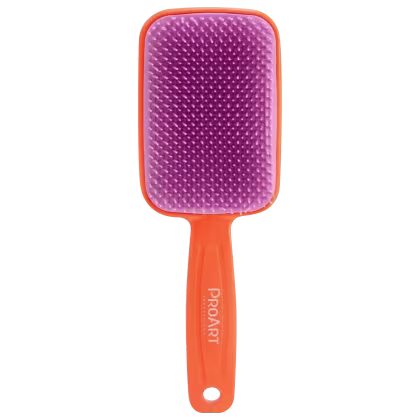 A imagem mostra uma escova com cabo laranja com o nome da marca "ProArt" impresso. Cabeça retangular grande com cerdas plásticas roxas densamente agrupadas. Cerdas apresentam uma textura pontiaguda para facilitar a escovação e modelagem do cabelo.