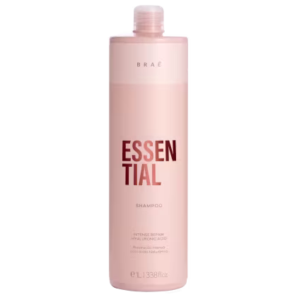 Frasco de shampoo da marca Braé, na cor rosa claro, com rótulo destacando o nome "Essential" e informações sobre o produto, como "Intense Repair" e "Hyaluronic Acid".