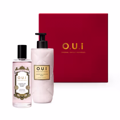 Conjunto de produtos de beleza da marca O.U.i, incluindo um frasco de colônia Jardin de Grasse Rose e um frasco de sabonete líquido, embalados em uma caixa vermelha com o logotipo da marca.