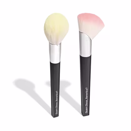 Dois pincéis de maquiagem da marca Quem Disse, Berenice? com cabelos macios em tons claros e escuros, com hastes pretas e detalhes em branco.