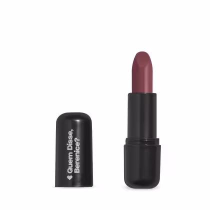 O produto apresentado na imagem é um batom da marca Quem Disse, Berenice?. O batom possui uma embalagem preta com o nome da marca em branco. O próprio batom tem uma cor marrom avermelhada.