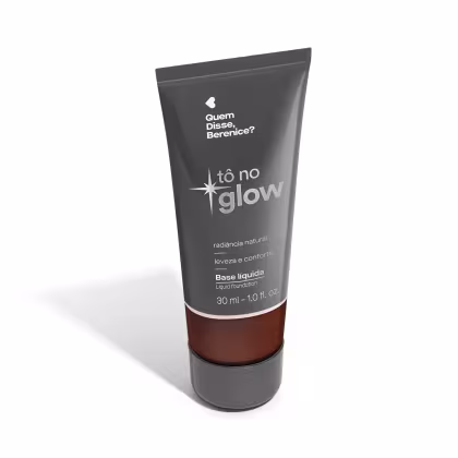 O produto apresentado é uma base líquida da marca Tô no Glow, com embalagem em tubo plástico de cor cinza escura. O rótulo exibe o nome da marca e o texto "Radiância natural, leveza e conforto" em letras brancas.