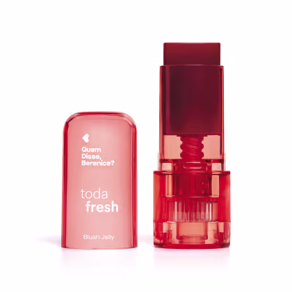 Produto de beleza da marca Quem Disse, Berenice? chamado "toda fresh", com embalagem em formato de batom vermelho e caixa rosa com texto em branco. O produto é um blush jelly, com textura e aparência gelatinosa.