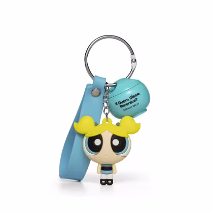 Chaveiro em formato da personagem Florzinha das Meninas Superpoderosas, com vestido azul e cabelo amarelo, preso a um produto da marca Quem Disse, Berenice?.
