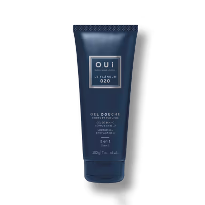 Embalagem tubo plástico azul marinho opaco metálico com tampa texturizada. Rótulo retangular branco com o nome da marca e linha em letras maiúsculas. Informações do produto em francês e inglês, incluindo peso líquido de 200g.