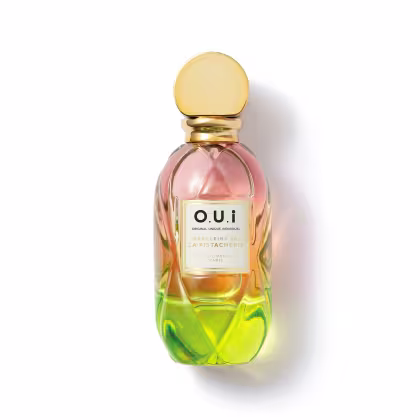 Frasco de perfume O.U.i. com design escultural em tons de rosa, amarelo e verde. Rótulo com nome da marca e informações sobre a fragrância "Madeleine 922 La Pistacherie".