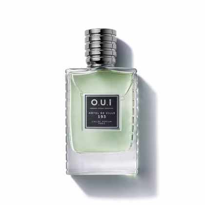Frasco de item de perfumaria da marca O.U.i, com formato retangular, tampa prateada e rótulo preto com texto "HOTEL DE VILLE 193" em fundo verde claro.