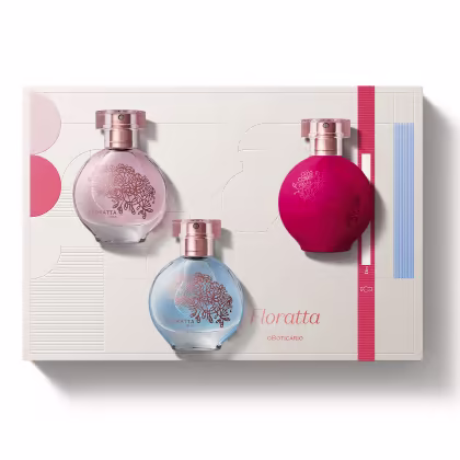 Conjunto de três frascos de perfume Floratta. Frascos de vidro arredondados com detalhes florais gravados, nas cores rosa claro, azul claro e rosa vibrante. Tampas de metal rosado. Embalagem retangular com faixas nas cores correspondentes aos frascos.