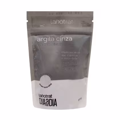 O produto mostrado na imagem é uma embalagem de argila cinza da marca Labotrat. A embalagem é um saco plástico selado com o nome do produto "argila cinza" e informações sobre seus benefícios, como efeito secativo das espinhas e oleosidade.