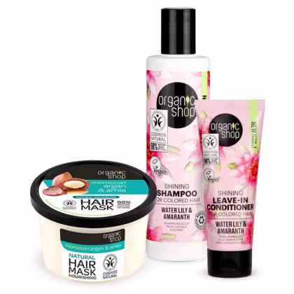 A imagem mostra o shampoo em frasco plástico transparente com rótulo rosa e branco com imagens de flores. Leave-in para em embalagem tubo com rótulo similar ao shampoo. Máscara capilar nutritiva em pote redondo com rótulo preto e azul.