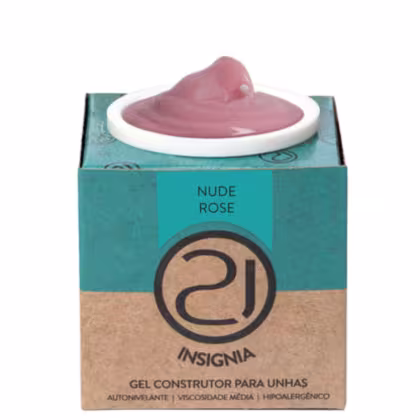 A imagem mostra o gel construtor para unhas em uma embalagem retangular de papelão na cor turquesa e bege, com o logotipo da marca em preto. Contém um pote branco com o produto gel em tom nude aparecendo no topo.