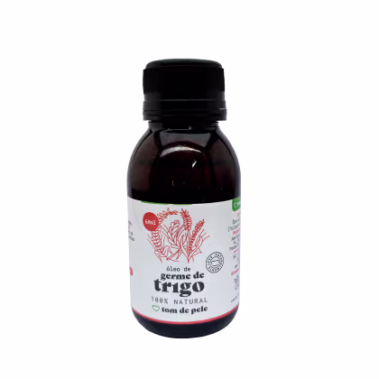 O produto apresentado é um óleo de germe de trigo da marca Tom de Pele. O frasco é de vidro escuro com um rótulo branco e vermelho. O rótulo indica que o produto é 100% natural. O frasco possui um tampa preta rosqueável.