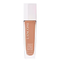 Frasco de maquiagem Lancôme Teint Idole Ultra Wear, com embalagem branca e detalhes em cobre. O produto é descrito como um "Care & Glow" com proteção solar FPS 15.