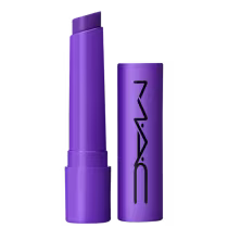A imagem mostra uma embalagem de balm labial, cilíndrica, toda roxa, com a tampa ao lado, também toda roxa com a logo da marca MAC, escrito em preto. Tem um pouco do balm, também roxo, à mostra.