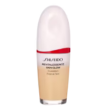 Base facial da marca Shiseido., Embalagem em forma de frasco plástico oval com uma faixa vermelha na parte superior. Rótulo indicando "Revitalessence Skin Glow Foundation" em letras pretas.