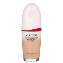 A imagem mostra um frasco de base líquida da marca Shiseido. O produto se chama "RevitaLessence Skin Glow Foundation". Trata-se de uma base com proteção solar SPF 30 e propriedades que prometem dar um brilho saudável à pele (skin glow).