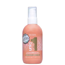 A imagem mostra o Leave-in Curls da linha Uniq One da Revlon Professional. Possui uma embalagem plástica arredondada na cor salmão com tampa branca e detalhes em dourado. Seu rótulo tem informações adicionais como volume e benefícios.