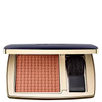Compacto de maquiagem Estée Lauder com blush de tom rosa claro e pincel aplicador em embalagem dourada e preta.