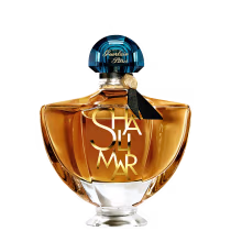 Frasco de perfume Guerlain Paris com tampa de cristal azul e rótulo dourado com a inscrição "Shalimar". Embalagem de vidro âmbar com design elegante e clássico.