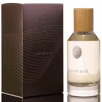 Caixa marrom escura com detalhes em relevo e logotipo do nome do perfume "Leather & Co." Frasco de perfume com tampa de bambu e rótulo com o mesmo nome da marca.