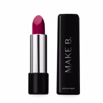 O produto é um batom de cor rosa intenso em uma embalagem cilíndrica prateada. Ao lado está a caixa preta do batom com o logotipo "MAKE B." em letras maiúsculas. O nome "oBoticario" também está impresso na caixa.