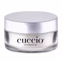 O produto apresentado é um pó cromo 3G da marca Cuccio. A embalagem é um recipiente circular de vidro transparente com uma tampa prateada. O rótulo do produto exibe claramente o nome "Cuccio" em letras pretas.