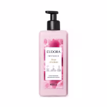 Creme hidratante desodorante corporal da linha Instance de Eudora. A embalagem é um frasco plástico rosa claro com um rótulo branco destacando o nome "Rosa Absoluta" e informações sobre o produto. O frasco possui um dispensador preto na parte superior.