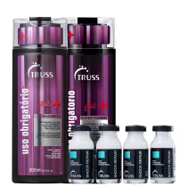 A imagem mostra um shampoo e um condicionador em frascos grandes de cor roxa com detalhes em preto, branco e vermelho. Além disso, há quatro frascos transparentes menores e com tampa preta.