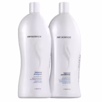 Dois frascos de shampoo e condicionador da marca Senscience, ambos com embalagens brancas e rótulos com o nome da marca. O shampoo é chamado de "Balance Shampoo" e o condicionador é chamado de "Balance Conditioner. Ambos tem 1 litro.