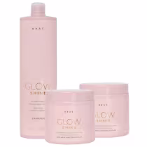 Produtos da linha Glow Shine da marca Braé, incluindo shampoo em frasco rosa, máscara capilar em pote rosa e embalagem rosa com detalhes dourados.