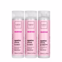 Dois shampoos e um condicionador com embalagens plásticas cilíndricas de 250ml cada. As cores predominantes são branco e rosa claro.