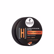 Pomada modeladora para cabelos masculinos Haskell. A embalagem é um recipiente preto redondo com um rótulo branco e laranja. O rótulo indica que a pomada possui fixação e efeito matte, além de conter ingredientes como café e zinco.