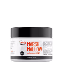É um produto de tratamento capilar da marca Curly Care. A embalagem é um pote plástico branco com tampa preta. Na frente, há o nome do produto "MarshMallow" em letras grandes e laranjas, seguido de "máscara HNR" em letras menores.