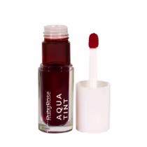 Lip tint Ruby Rose em um tom vermelho escuro. Ao lado do frasco o seu aplicador.