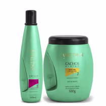 A imagem mostra um kit com dois produtos, sendo um frasco cilíndrico com o shampoo e um pote redondo de máscara. Ambos possuem uma cor verde clara.
