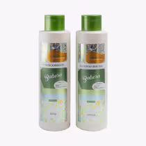 São dois frascos de plástico brancos com tampas verdes. Um frasco é de condicionador e o outro de shampoo sem sal. Ambos têm rótulos com detalhes em tons de verde, azul, amarelo e laranja em um padrão floral abstrato.