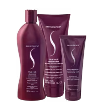 Três produtos da marca Senscience: um frasco de shampoo True Hue, um tubo de condicionador True Hue e um tubo de máscara Inner Restore, todos em tons de vermelho escuro.