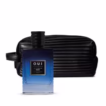 A imagem mostra um eau de parfum com um frasco quadrado de vidro azul escuro com a tampa preta. O rótulo mostra o nome da marca "O.U.i" e a inscrição "Le Flâneur 028". Ao lado está uma necessaire preta com listras horizontais texturizadas.