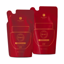 Dois pacotes de recarga da marca O.U.i. em vermelho e dourado, contendo o produto "Crème Riche", uma creme hidratante desodorante. Os pacotes possuem informações sobre o conteúdo e a marca impressas em letras douradas.