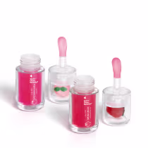 Conjunto de produtos de beleza em embalagens de vidro transparente, com rótulos em vermelho e rosa, contendo um batom e um creme para os lábios com aroma de morango.
