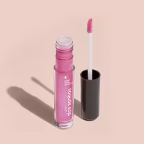 Frasco cilíndrico transparente contendo um brilho labial rosa brilhante. Rótulo na embalagem com o nome do produto "Gloss dos Sonhos" e a descrição "Quem disse, berence?". Ao lado, a tampa preta do produto, que acompanha um aplicador de espuma rosa.
