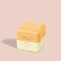 Balm Labial em formato hexagonal, com duas seções de cores distintas de amarelo. A parte superior é amarela com um desenho estilizado de uma abelha. Há um texto em português que diz "Quem disse, Berenice?" e "Oboticario CUIDE-SE BEM".