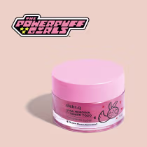 Embalagem rosa de um hidratante labial da marca "The Powerpuff Girls", com o texto "Uma heroína o tempo todo" e ilustrações da personagem Florzinha.