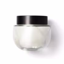 Frasco de vidro arredondado, transparente com tampa preta de rosquear, contendo o creme na cor branca. Design minimalista e elegante.