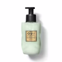 Frasco tipo pump de sabonete líquido da marca O.U.i. com rótulo em fundo verde-claro e detalhes dourados, contendo a descrição "Jardin de Grasse Sauge Blanche" (Jardim de Grama Branca).
