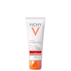 Tubo branco e laranja da linha Vichy Laboratoires, contendo protetor solar FPS 60 com controle de pigmentação UV. Rótulo com informações sobre o produto e sua fórmula 3 em 1.