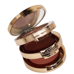 A embalagens é composta por várias camadas circulares que se encaixam, com superfícies espelhadas e detalhes metálicos brilhantes. As tampas superiores são achatadas e apresentam um acabamento liso e polido.